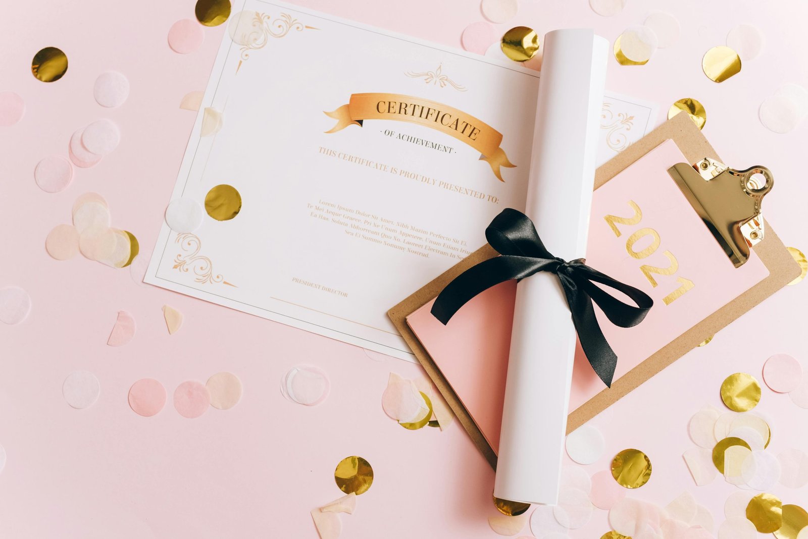 A rolled-up diploma with a certificate of achievement surrounded by confetti, perfect for graduation themes.